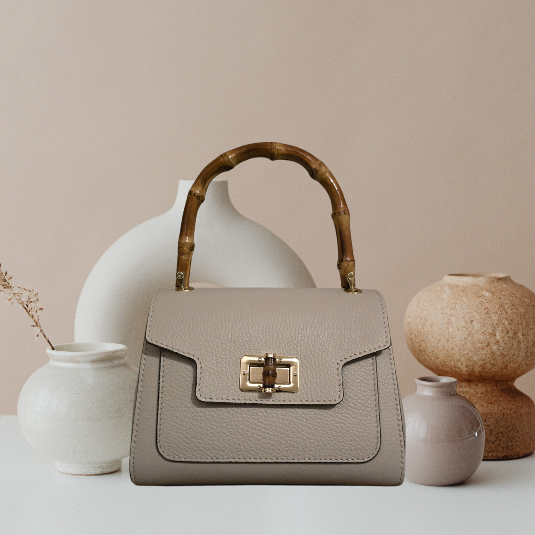 Beige Tas met Bamboe handvaten en gouden details.